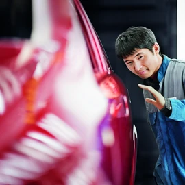 Perfect finish Employee checking the paint finish of a car